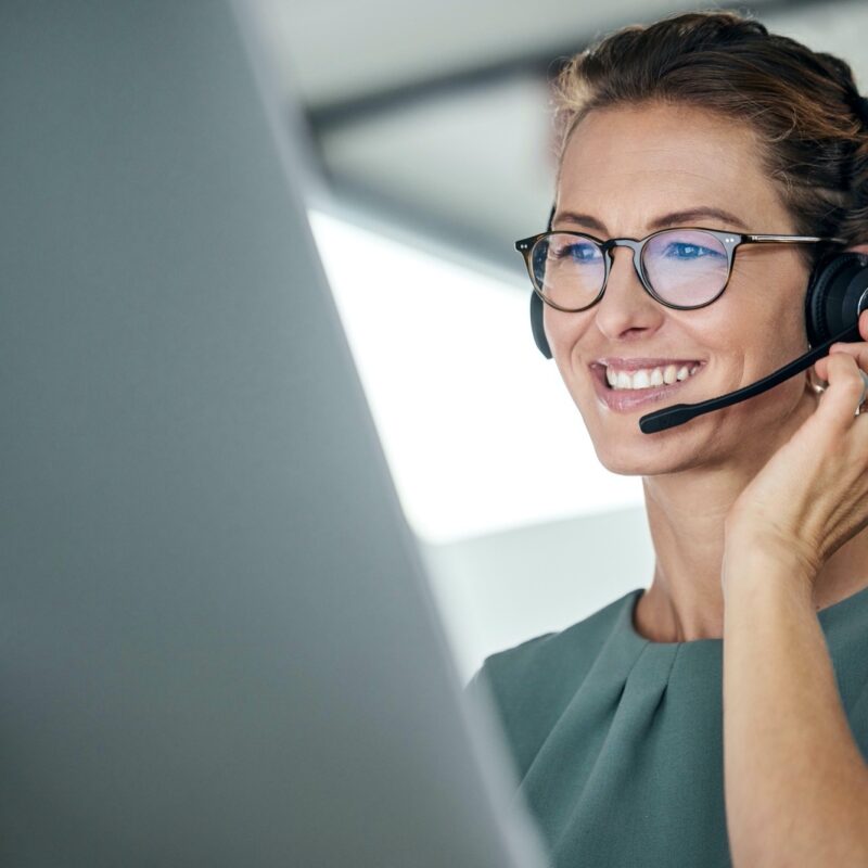 Customer service, woman and happy call center agent giving advice online using a headset. Operator, telemarketing and support with hotline consultant working for contact us help or arm consulting.